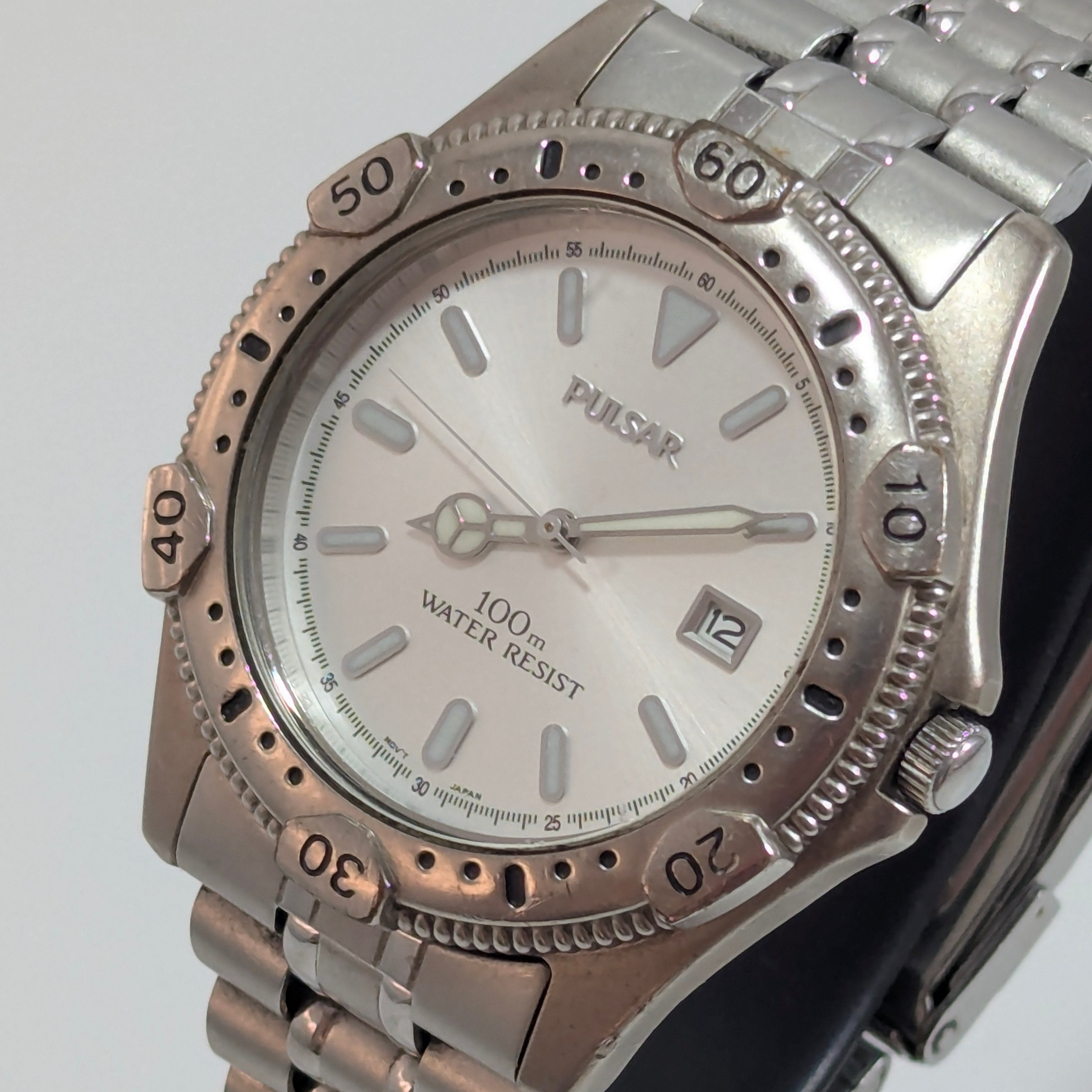 Vintage 1990s Pulsar stainless steel diver-style watch, 38mm, white dial with luminous baton indices, rotating elapsed-time bezel, date at 3 o'clock, three-quarter view